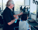 Allan at Hair Frame applying hairspray to client’s hair to add shine and volume during styling.