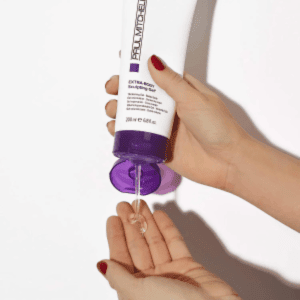 Paul Mitchell product being dispensed into hand, highlighting texture and usability.